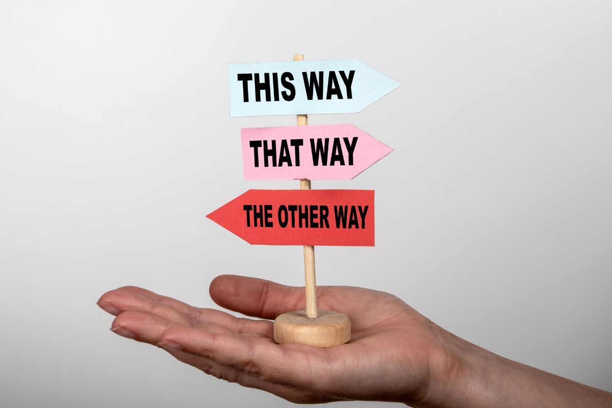 Overthinking - person holding a sign in their hand that points different directions and says this way, that way, the other way.