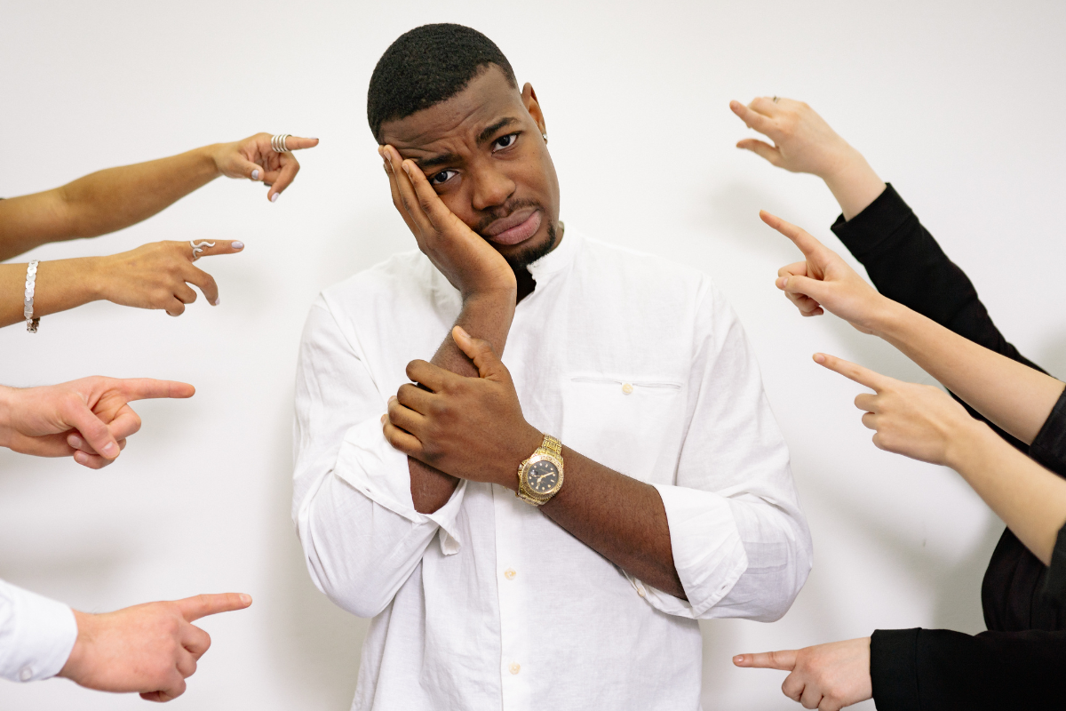 Man suffering from anxiety with everyone expecting things from him and pointing at him