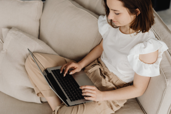 online therapy - woman sitting on sofa talking on her computer