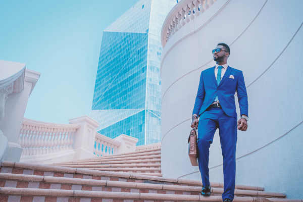 successful man who looks like he has it all together standing on a beautiful staircase near a high rise building.