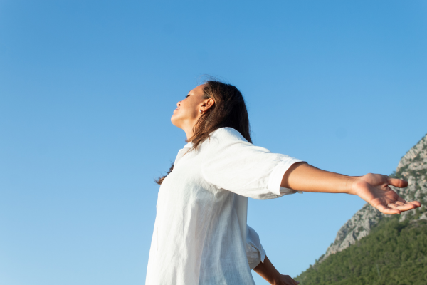 Therapist can help you understand how to calm your nervous system during anxiety and chronic stress. - Image reflects woman on hillside calming her nervous system.
